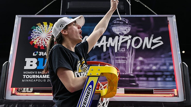 Mar 10, 2024; Minneapolis, MN, USA; Iowa Hawkeyes guard Caitlin Clark (22) cuts a piece off the net after the game against the Nebraska Cornhuskers at Target Center. Mandatory Credit: Matt Krohn-USA TODAY Sports