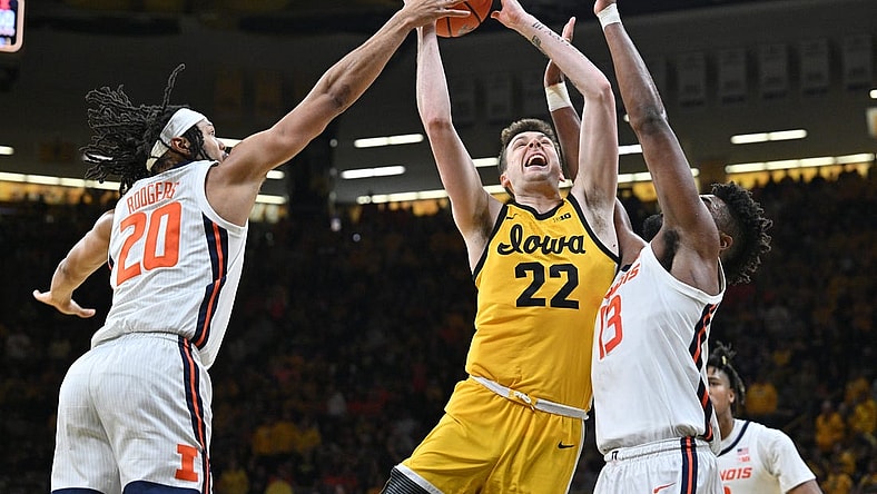 Mar 10, 2024; Iowa City, Iowa, USA; Iowa Hawkeyes forward Payton Sandfort (20) is defended by Illinois Fighting Illini forward Ty Rodgers (20) and forward Quincy Guerrier (13) during the second half at Carver-Hawkeye Arena. Mandatory Credit: Jeffrey Becker-USA TODAY Sports