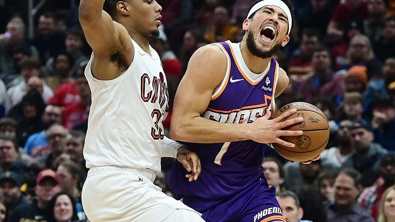 Mar 11, 2024; Cleveland, Ohio, USA; Phoenix Suns guard Devin Booker (1) drives to the basket against Cleveland Cavaliers forward Isaac Okoro (35) during the first half at Rocket Mortgage FieldHouse. Mandatory Credit: Ken Blaze-USA TODAY Sports