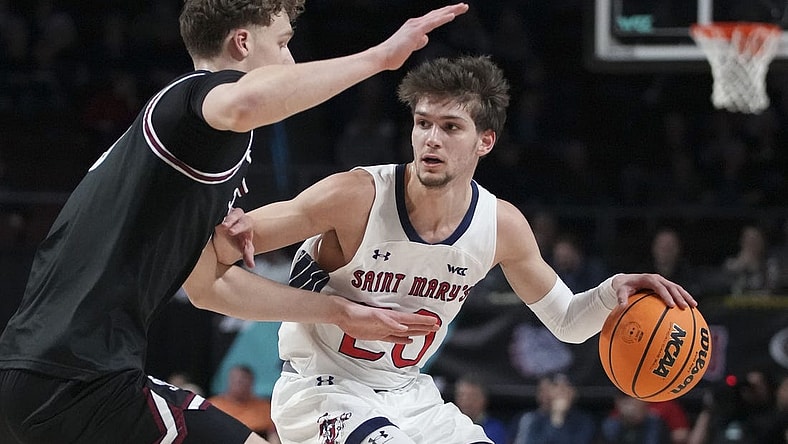 March 11, 2024; Las Vegas, NV, USA; Saint Mary's Gaels guard Aidan Mahaney (20) dribbles the basketball against Santa Clara Broncos center Christoph Tilly (13) during the first half in the semifinals of the WCC Basketball Championship at Orleans Arena. Mandatory Credit: Kyle Terada-USA TODAY Sports