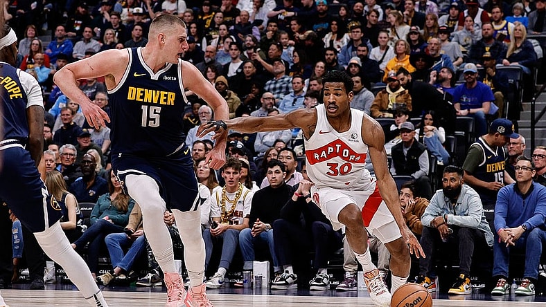 Mar 11, 2024; Denver, Colorado, USA; Toronto Raptors guard Ochai Agbaji (30) drives to the basket against Denver Nuggets center Nikola Jokic (15) in the second quarter at Ball Arena. Mandatory Credit: Isaiah J. Downing-USA TODAY Sports