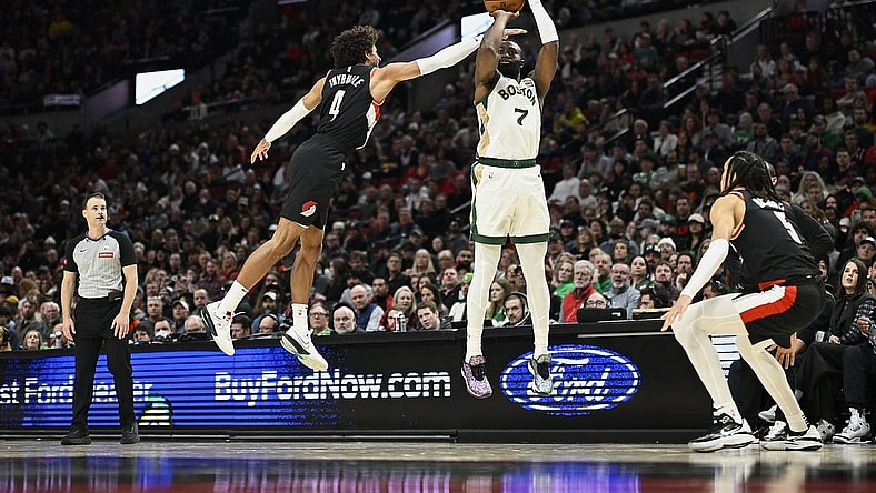 Mar 11, 2024; Portland, Oregon, USA; Boston Celtics guard Jaylen Brown (7) shoots a three point jump shot during the first half against Portland Trail Blazers guard Matisse Thybulle (4) and guard Dalano Banton (5) at Moda Center. Mandatory Credit: Troy Wayrynen-USA TODAY Sports