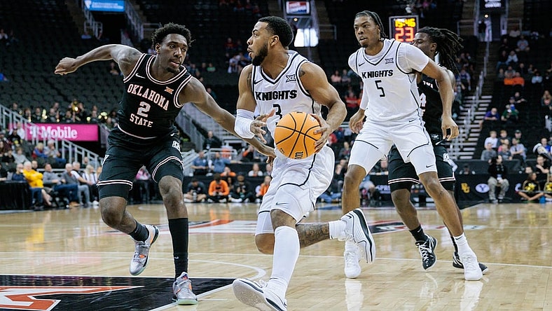 Mar 12, 2024; Kansas City, MO, USA; UCF Knights guard Darius Johnson (3) drives to the basket around Oklahoma State Cowboys forward Eric Dailey Jr. (2) during the first half at T-Mobile Center. Mandatory Credit: William Purnell-USA TODAY Sports