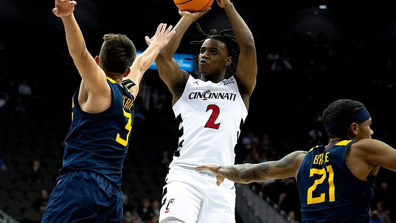 Cincinnati Bearcats guard Jizzle James (2) hits a 3-point basket as West Virginia Mountaineers guard Kerr Kriisa (3) defends in the first half of the Big 12 Conference tournament between Cincinnati Bearcats and West Virginia Mountaineers at T-Mobile Center in Kansas City, Mo., on Tuesday, March 12, 2024.