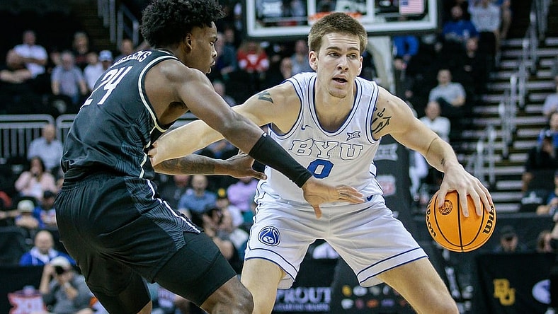 Mar 13, 2024; Kansas City, MO, USA; Brigham Young Cougars forward Noah Waterman (0) brings the ball up court around UCF Knights guard Jaylin Sellers (24) during the first half at T-Mobile Center. Mandatory Credit: William Purnell-USA TODAY Sports