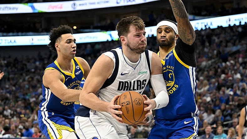 Mar 13, 2024; Dallas, Texas, USA; Dallas Mavericks guard Luka Doncic (77) drives to the basket past Golden State Warriors forward Trayce Jackson-Davis (32) and guard Gary Payton II (0) during the first half at the American Airlines Center. Mandatory Credit: Jerome Miron-USA TODAY Sports
