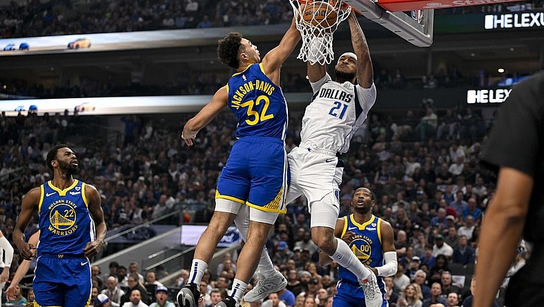 Mar 13, 2024; Dallas, Texas, USA; Dallas Mavericks center Daniel Gafford (21) dunks the ball past Golden State Warriors forward Trayce Jackson-Davis (32) during the first quarter at the American Airlines Center. Mandatory Credit: Jerome Miron-USA TODAY Sports