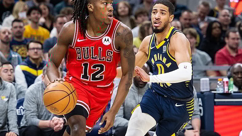 Mar 13, 2024; Indianapolis, Indiana, USA; Chicago Bulls guard Ayo Dosunmu (12) dribbles the ball while Indiana Pacers guard Tyrese Haliburton (0) defends in the first half at Gainbridge Fieldhouse. Mandatory Credit: Trevor Ruszkowski-USA TODAY Sports