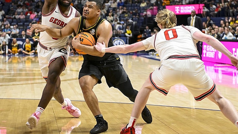 Mar 13, 2024; Nashville, TN, USA;  Missouri Tigers guard Nick Honor (10) splits Georgia Bulldogs guard Blue Cain (0) and forward Jalen DeLoach (23) during the first half at Bridgestone Arena. Mandatory Credit: Steve Roberts-USA TODAY Sports