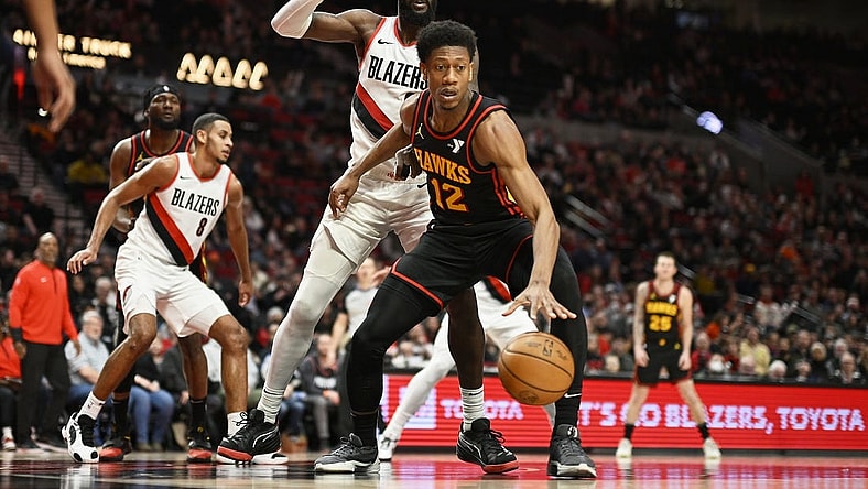 Mar 13, 2024; Portland, Oregon, USA; Atlanta Hawks forward De'Andre Hunter (12) dribbles the basketball during the second half against Portland Trail Blazers center Deandre Ayton (2) at Moda Center. Mandatory Credit: Troy Wayrynen-USA TODAY Sports