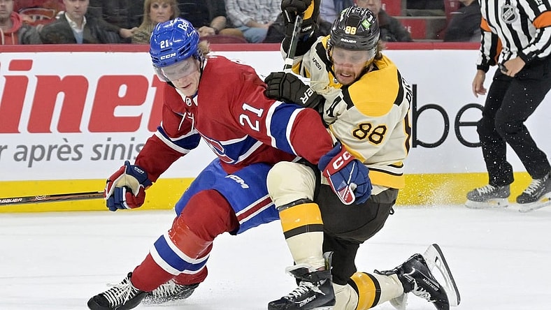 Mar 14, 2024; Montreal, Quebec, CAN; Montreal Canadiens defenseman Kaiden Guhle (21) checks Boston Bruins forward David Pastrnak (88) during the first period at the Bell Centre. Mandatory Credit: Eric Bolte-USA TODAY Sports
