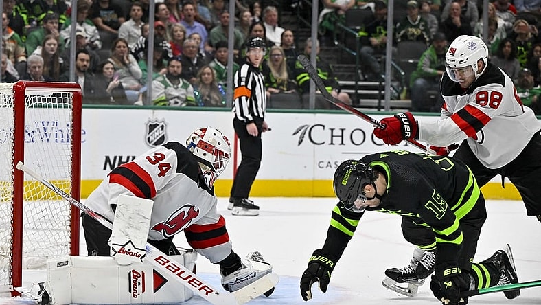 Mar 14, 2024; Dallas, Texas, USA; New Jersey Devils defenseman Kevin Bahl (88) is called for a cross check on Dallas Stars left wing Jamie Benn (14) as goaltender Jake Allen (34) covers the puck during the second period at the American Airlines Center. Mandatory Credit: Jerome Miron-USA TODAY Sports