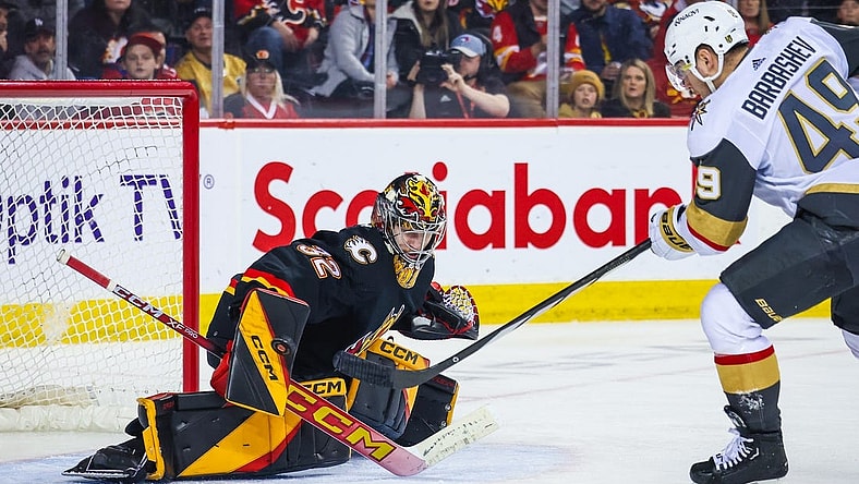 Mar 14, 2024; Calgary, Alberta, CAN; Calgary Flames goaltender Dustin Wolf (32) makes a save against Vegas Golden Knights center Ivan Barbashev (49) during the third period at Scotiabank Saddledome. Mandatory Credit: Sergei Belski-USA TODAY Sports