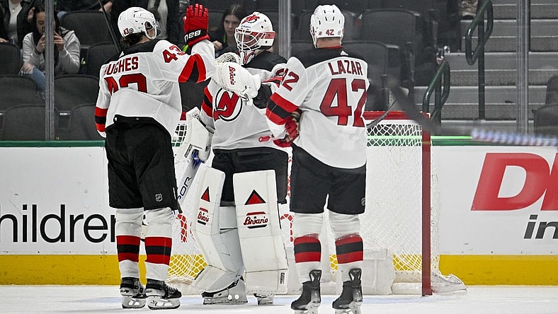 Mar 14, 2024; Dallas, Texas, USA; New Jersey Devils defenseman Luke Hughes (43) and center Curtis Lazar (42) and goaltender Jake Allen (34) celebrate on the ice after the Devils defeat the Dallas Stars at the American Airlines Center. Mandatory Credit: Jerome Miron-USA TODAY Sports