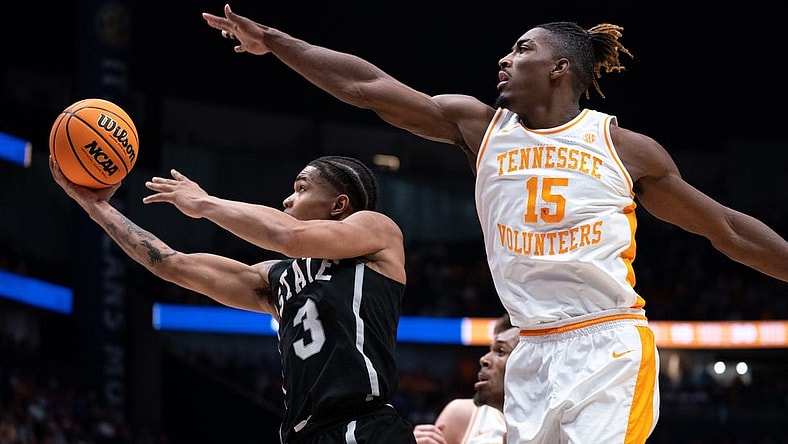 Mississippi State Bulldogs guard Shakeel Moore (3) eludes Tennessee Volunteers guard Jahmai Mashack (15) for a layup during their SEC Men's Basketball Tournament quarterfinal game at Bridgestone Arena in Nashville, Tenn., Friday, March 15, 2024.