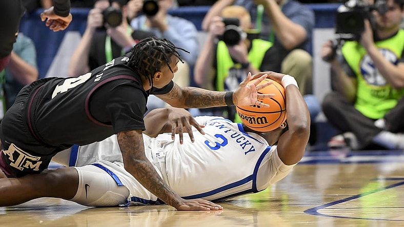 Mar 15, 2024; Nashville, TN, USA; Texas A&M Aggies guard Wade Taylor IV (4) and Kentucky Wildcats guard Adou Thiero (3) fight for the loose ball during the first half at Bridgestone Arena. Mandatory Credit: Steve Roberts-USA TODAY Sports