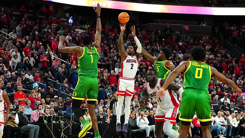 Mar 15, 2024; Las Vegas, NV, USA; Arizona Wildcats guard Caleb Love (2) shoots between Oregon Ducks center N'Faly Dante (1) and Oregon Ducks guard Jermaine Couisnard (5) during the second half at T-Mobile Arena. Mandatory Credit: Stephen R. Sylvanie-USA TODAY Sports