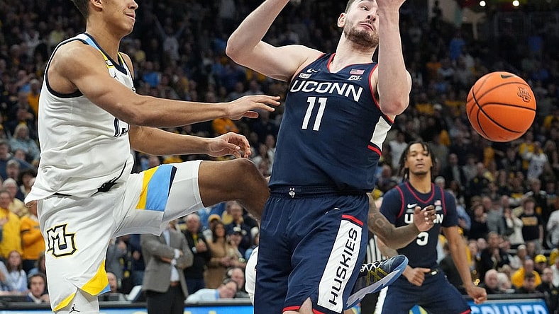 Marquette's Oso Ighodaro (13) swats the ball away from UConn forward Alex Karaban (11) during the second half of their game Wednesday, March 6, 2024 at Fiserv Forum in Milwaukee, Wisconsin. UConn beat Marquette 74-67.