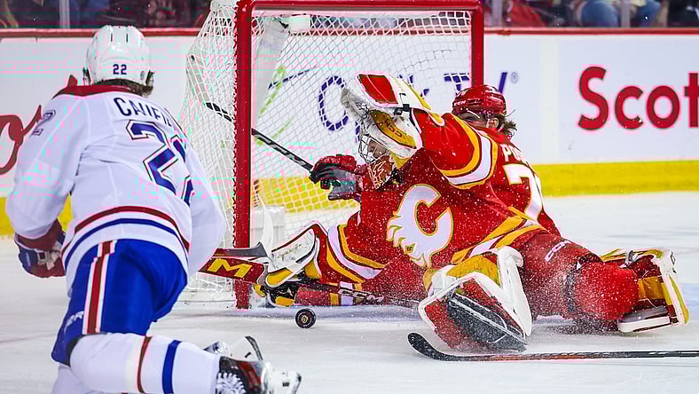 Mar 16, 2024; Calgary, Alberta, CAN; Calgary Flames goaltender Dustin Wolf (32) makes a save against Montreal Canadiens right wing Cole Caufield (22) during the first period at Scotiabank Saddledome. Mandatory Credit: Sergei Belski-USA TODAY Sports