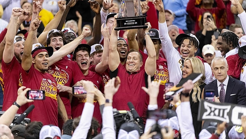 Mar 16, 2024; Kansas City, MO, USA; Iowa State Cyclones head coach TJ Otzelberger hoists the Big 12 Tournament trophy alongside his team after defeating the Houston Cougars at T-Mobile Center. Mandatory Credit: Amy Kontras-USA TODAY Sports
