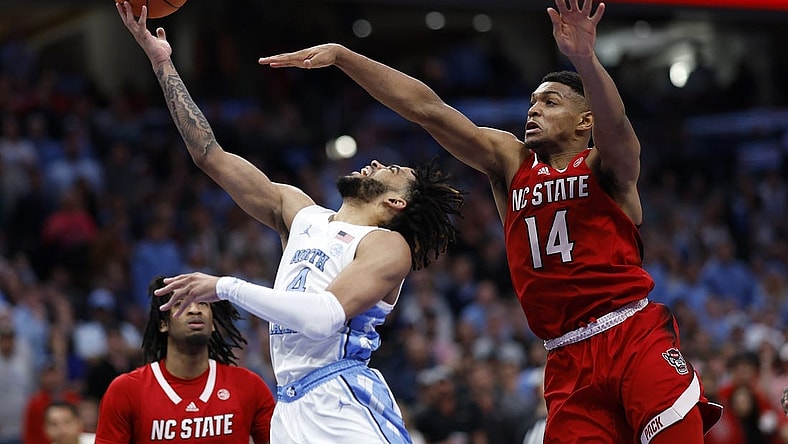 Mar 16, 2024; Washington, D.C., USA; North Carolina Tar Heels guard RJ Davis (4) shoots the ball against North Carolina State Wolfpack guard Casey Morsell (14) during the second half at Capital One Arena. Mandatory Credit: Geoff Burke-USA TODAY Sports