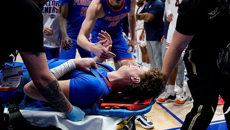 Florida center Micah Handlogten (3) is tended to after an injury during the first half of the SEC tournament championship game against Auburn at Bridgestone Arena in Nashville, Tenn., Sunday, March 17, 2024.