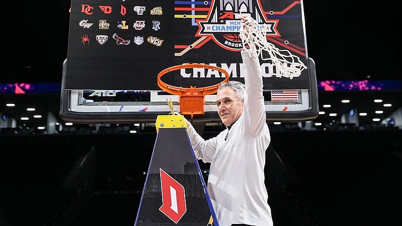 Mar 17, 2024; Brooklyn, NY, USA;  Duquesne Dukes head coach Keith Dambrot cuts the nets after winning the Atlantic 10 Tournament Championship at Barclays Center. Mandatory Credit: Wendell Cruz-USA TODAY Sports