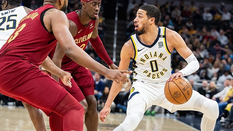 Mar 18, 2024; Indianapolis, Indiana, USA; Indiana Pacers guard Tyrese Haliburton (0) dribbles the ball while Cleveland Cavaliers guard Caris LeVert (3) defends in the first half at Gainbridge Fieldhouse. Mandatory Credit: Trevor Ruszkowski-USA TODAY Sports