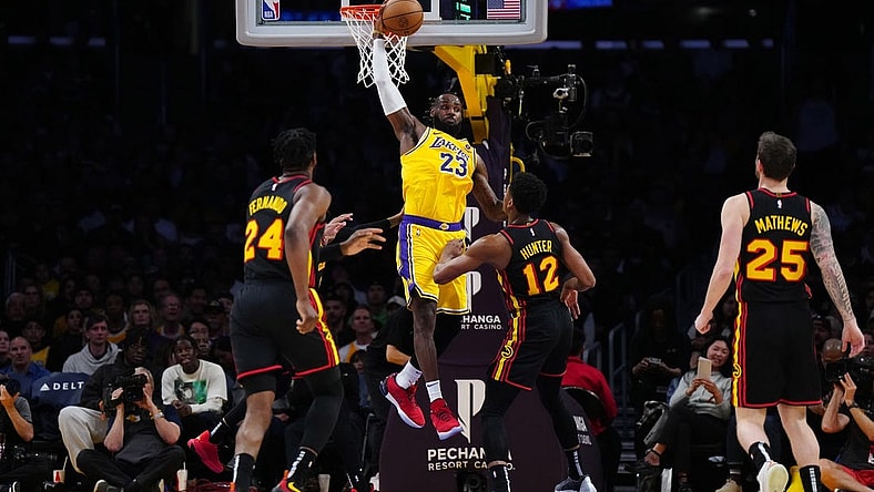 Mar 18, 2024; Los Angeles, California, USA; Los Angeles Lakers forward LeBron James (23) reaches for the ball against Atlanta Hawks forward Bruno Fernando (24), Atlanta Hawks forward De'Andre Hunter (12) and guard Garrison Mathews (25) in the first half at Crypto.com Arena. Mandatory Credit: Kirby Lee-USA TODAY Sports