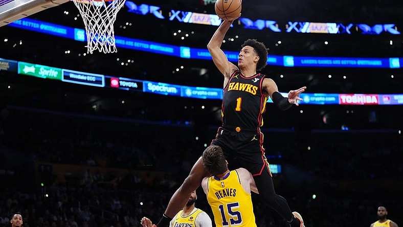 Mar 18, 2024; Los Angeles, California, USA; Atlanta Hawks forward Jalen Johnson (1) dunks the ball over Los Angeles Lakers guard Austin Reaves (15) in the first half at Crypto.com Arena. Mandatory Credit: Kirby Lee-USA TODAY Sports