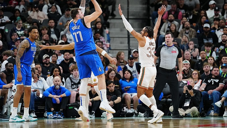 Mar 19, 2024; San Antonio, Texas, USA;  Dallas Mavericks guard Luka Doncic (77) shoots over San Antonio Spurs guard Tre Jones (33) in the first half at Frost Bank Center. Mandatory Credit: Daniel Dunn-USA TODAY Sports