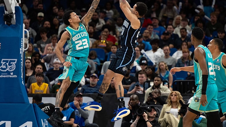 Mar 19, 2024; Orlando, Florida, USA; Orlando Magic guard Cole Anthony (50) shoots the ball over Charlotte Hornets guard Tre Mann (23) in the fourth quarter at KIA Center. Mandatory Credit: Jeremy Reper-USA TODAY Sports