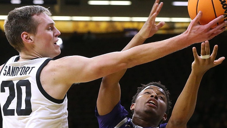 Iowa   s Payton Sandfort (20) and Kansas State   s Tylor Perry (2) reach for a loose ball in a first-round NIT game Tuesday, March 19, 2024 at Carver-Hawkeye Arena in Iowa City, Iowa.