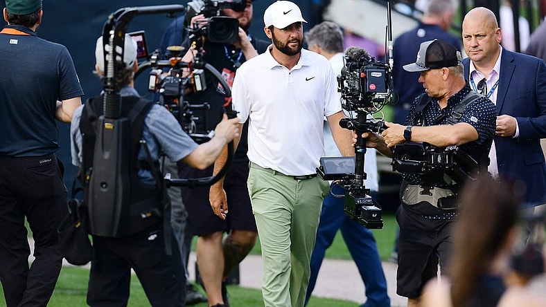 Scottie Scheffler is surrounded by cameras as he makes his way to the trophy riser after winning the tournament for the second year in a row at The Players Championship PGA golf tournament Sunday, March 17, 2024 at TPC Sawgrass in Ponte Vedra Beach, Fla.
