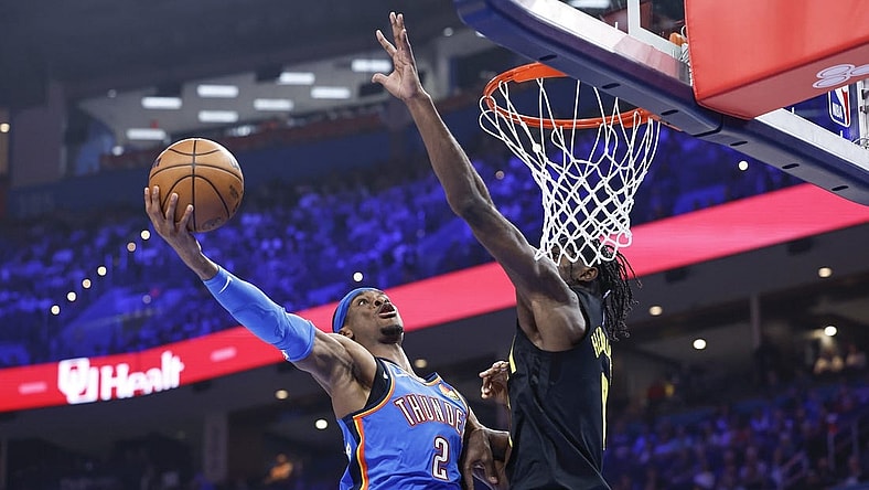 Mar 20, 2024; Oklahoma City, Oklahoma, USA; Oklahoma City Thunder guard Shai Gilgeous-Alexander (2) goes to the basket as Utah Jazz forward Taylor Hendricks (0) defends during the second quarter at Paycom Center. Mandatory Credit: Alonzo Adams-USA TODAY Sports