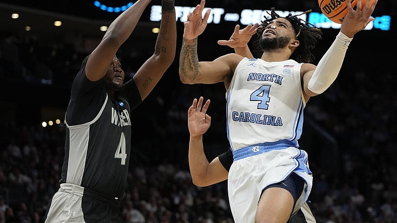 March 21, 2024, Charlotte, NC, USA; North Carolina Tar Heels guard RJ Davis (4) shoots against Wagner Seahawks forward Tyje Kelton (4) in the first round of the 2024 NCAA Tournament at the Spectrum Center. Mandatory Credit: Bob Donnan-USA TODAY Sports