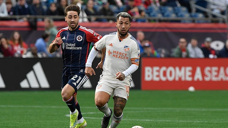 Mar 17, 2024; Foxborough, Massachusetts, USA;  FC Cincinnati midfielder Luciano Acosta (10) controls the ball while New England Revolution midfielder Nacho Gil (21) defends during the second half at Gillette Stadium. Mandatory Credit: Bob DeChiara-USA TODAY Sports