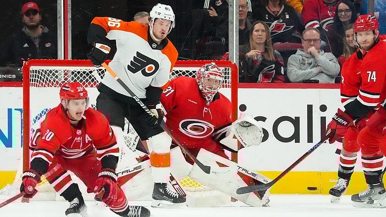 Mar 21, 2024; Raleigh, North Carolina, USA; Carolina Hurricanes goaltender Frederik Andersen (31) and Philadelphia Flyers left wing Joel Farabee (86) watch the shot during the first period at PNC Arena. Mandatory Credit: James Guillory-USA TODAY Sports
