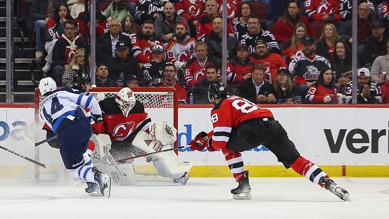 Mar 21, 2024; Newark, New Jersey, USA; New Jersey Devils goaltender Jake Allen (34) makes a save on Winnipeg Jets defenseman Josh Morrissey (44) during the second period at Prudential Center. Mandatory Credit: Ed Mulholland-USA TODAY Sports