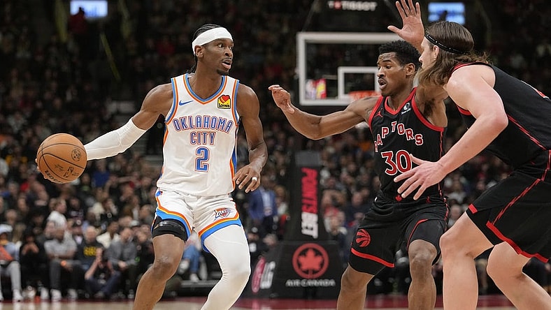 Mar 22, 2024; Toronto, Ontario, CAN; Oklahoma City Thunder guard Shai Gilgeous-Alexander (2) looks to make a play against Toronto Raptors guard Ochai Agbaji (30) and  forward Kelly Olynyk (41) during the first half at Scotiabank Arena. Mandatory Credit: John E. Sokolowski-USA TODAY Sports