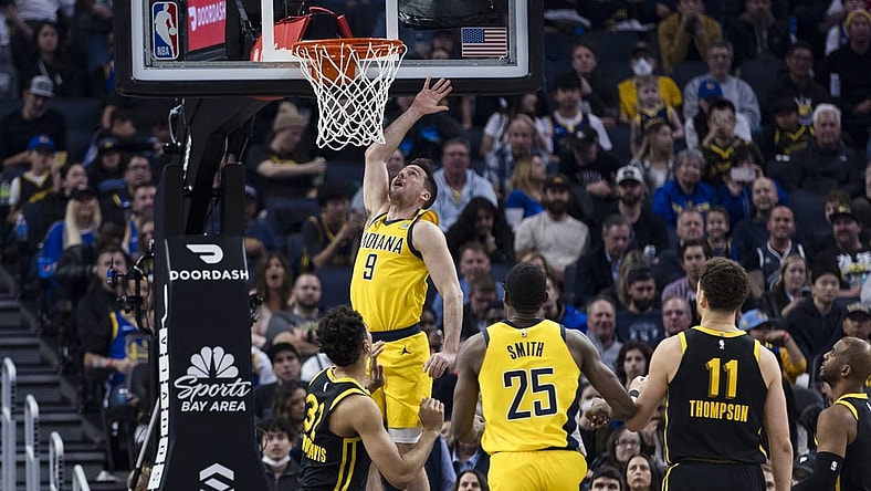 Mar 22, 2024; San Francisco, California, USA; Indiana Pacers guard T.J. McConnell (9) shoots in front of forward Jalen Smith (25) and Golden State Warriors center Trayce Jackson-Davis (32) during the first half at Chase Center. Mandatory Credit: John Hefti-USA TODAY Sports
