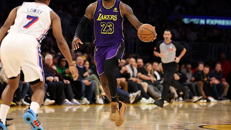 Mar 22, 2024; Los Angeles, California, USA;  Los Angeles Lakers forward LeBron James (23) dribbles the ball against Philadelphia 76ers guard Kyle Lowry (7) during the fourth quarter at Crypto.com Arena. Mandatory Credit: Kiyoshi Mio-USA TODAY Sports