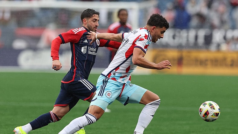 Mar 23, 2024; Foxborough, Massachusetts, USA; Chicago Fire FC defender Allan Arigoni (27) plays the ball defended by New England Revolution midfielder Nacho Gil (21) in the first half at Gillette Stadium. Mandatory Credit: Paul Rutherford-USA TODAY Sports