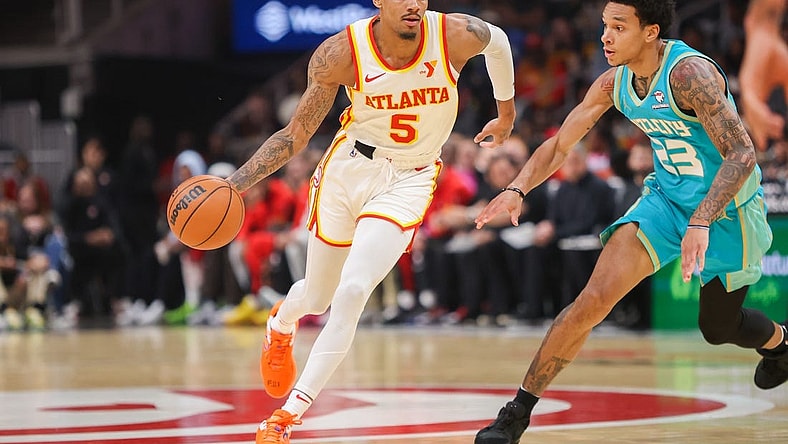 Mar 23, 2024; Atlanta, Georgia, USA; Atlanta Hawks guard Dejounte Murray (5) is defended by Charlotte Hornets guard Tre Mann (23) in the first quarter at State Farm Arena. Mandatory Credit: Brett Davis-USA TODAY Sports