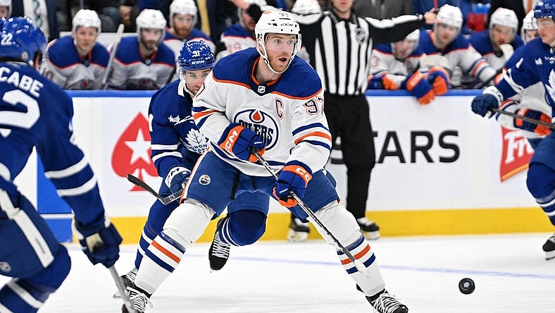 Mar 23, 2024; Toronto, Ontario, CAN; Edmonton Oilers forward Connor McDavid (97) passes the puck against the Toronto Maple Leafs in the second period at Scotiabank Arena. Mandatory Credit: Dan Hamilton-USA TODAY Sports