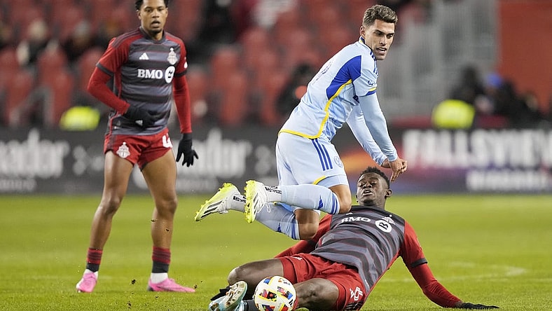 Mar 23, 2024; Toronto, Ontario, USA; Atlanta United forward Daniel Rios (19) fights for the ball Toronto FC defender Aime Mabika (6) during the second half at BMO Field. Mandatory Credit: John E. Sokolowski-USA TODAY Sports