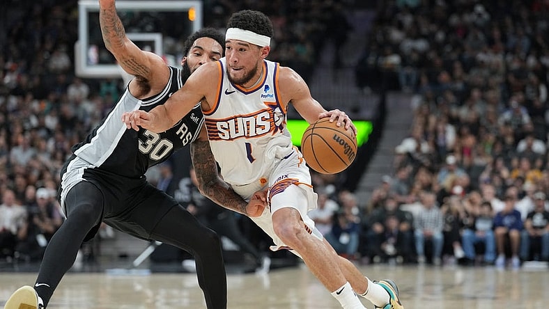 Mar 23, 2024; San Antonio, Texas, USA;  Phoenix Suns guard Devin Booker (1) dribbles against San Antonio Spurs forward Julian Champagnie (30) in the second half at Frost Bank Center. Mandatory Credit: Daniel Dunn-USA TODAY Sports