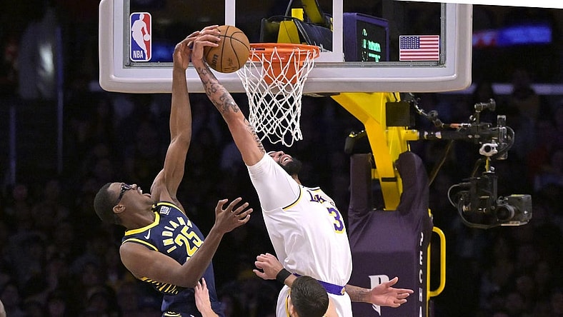 Mar 24, 2024; Los Angeles, California, USA;   Los Angeles Lakers forward Anthony Davis (3) grabs his own rebound and scores past Indiana Pacers forward Jalen Smith (25) in the first half at Crypto.com Arena. Mandatory Credit: Jayne Kamin-Oncea-USA TODAY Sports