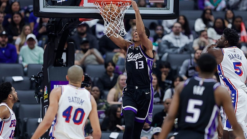 Mar 25, 2024; Sacramento, California, USA; Sacramento Kings forward Keegan Murray (13) dunks the ball against Philadelphia 76ers forward Nicolas Batum (40) during the first quarter at Golden 1 Center. Mandatory Credit: Sergio Estrada-USA TODAY Sports