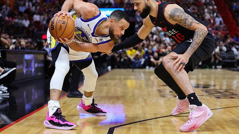 Mar 26, 2024; Miami, Florida, USA; Golden State Warriors guard Stephen Curry (30) protects the basketball from Miami Heat forward Caleb Martin (16) during the first quarter at Kaseya Center. Mandatory Credit: Sam Navarro-USA TODAY Sports